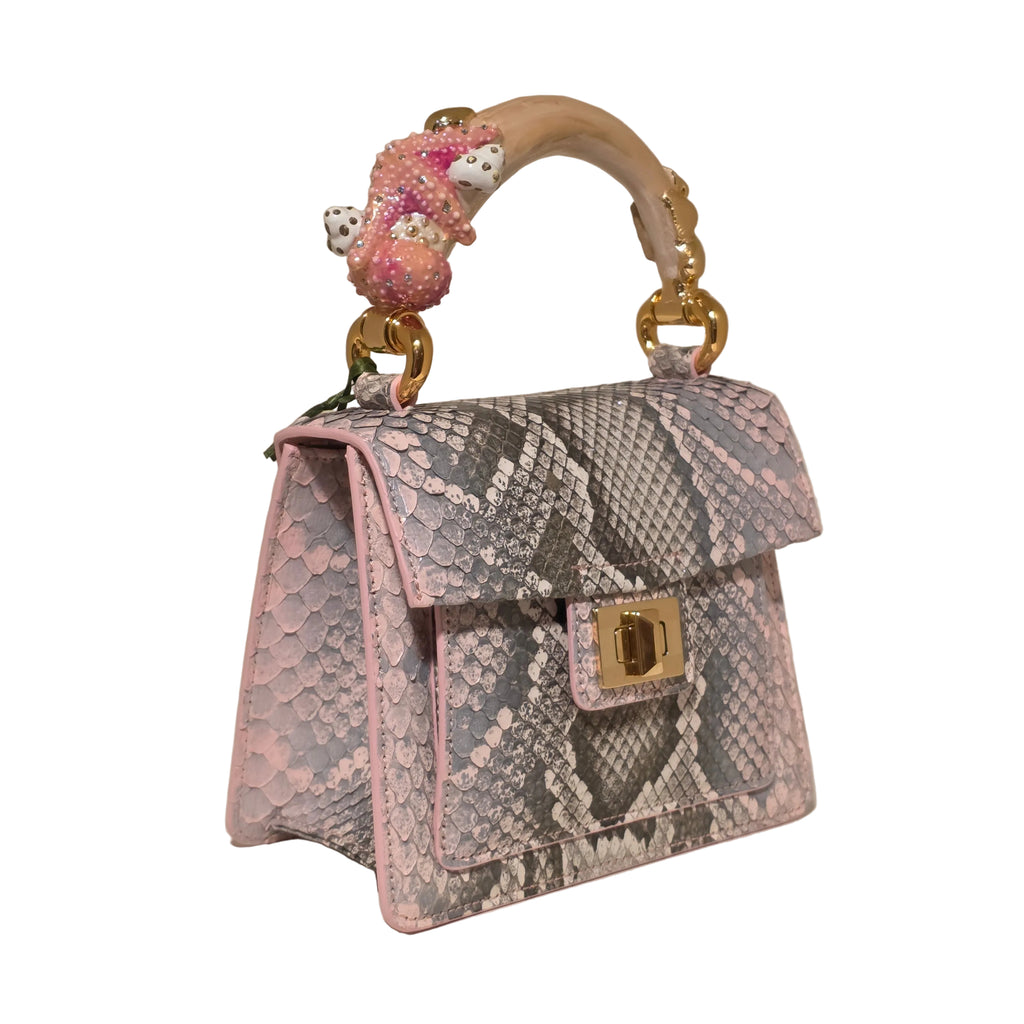 Biagini Art Bag –

Handcrafted in Bologna, Italy since 1968, the Biagini Art Bag is a masterclass in exquisite Italian artistry and uncompromising luxury. Designed to make a statement, this piece showcases genuine python finishes paired with rich, sumptuous suede interior lining. Every detail is meticulously finished, featuring a distinctive hand-painted enameled brass handle and gleaming gold-tone hardware.

Craftsmanship: Made in Italy
Brought to you by Rise And Shine Haven - BellaBarra.store