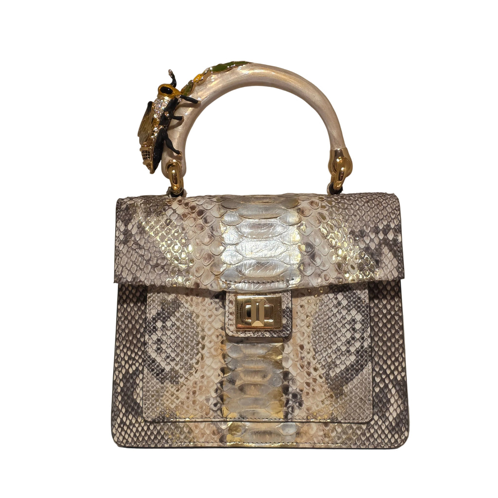 Biagini Art Bag –

Handcrafted in Bologna, Italy since 1968, the Biagini Art Bag is a masterclass in exquisite Italian artistry and uncompromising luxury. Designed to make a statement, this piece showcases genuine python finishes paired with rich, sumptuous suede interior lining. Every detail is meticulously finished, featuring a distinctive hand-painted enameled brass handle and gleaming gold-tone hardware.

Craftsmanship: Made in Italy
Brought to you by Rise And Shine Haven - BellaBarra.store
