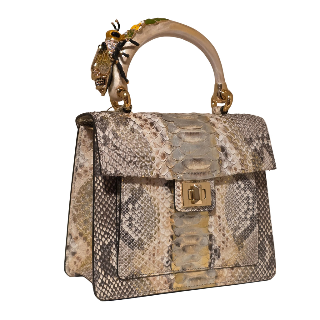 Biagini Art Bag –

Handcrafted in Bologna, Italy since 1968, the Biagini Art Bag is a masterclass in exquisite Italian artistry and uncompromising luxury. Designed to make a statement, this piece showcases genuine python finishes paired with rich, sumptuous suede interior lining. Every detail is meticulously finished, featuring a distinctive hand-painted enameled brass handle and gleaming gold-tone hardware.

Craftsmanship: Made in Italy
Brought to you by Rise And Shine Haven - BellaBarra.store